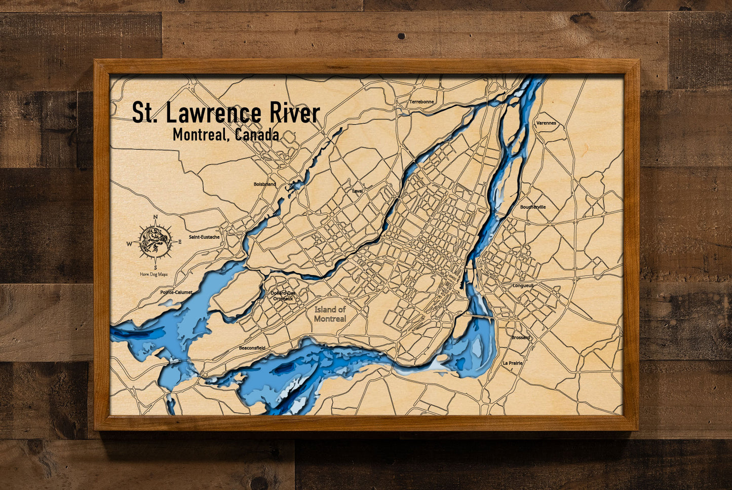 An aerial view capturing the wide expanse of the St. Lawrence River as it flows past the verdant Island of Montreal. The city's skyline, bridges, and the natural contours of the island are visible against the backdrop of the powerful waterway. The image emphasizes the river's scale and its significant geographical and urban presence.