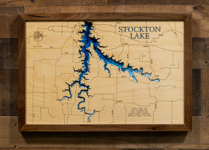 A laser-cut, layered wooden map of Stockton Lake, located in Cedar, Dade, and Polk Counties, Missouri. The intricate and extensive shoreline of the reservoir is clearly depicted, showcasing its significant size within southwest Missouri. The varying depths of the lake, reaching a maximum of 153 feet, are represented by different layers of wood, creating a three-dimensional effect of this prominent Missouri water body.