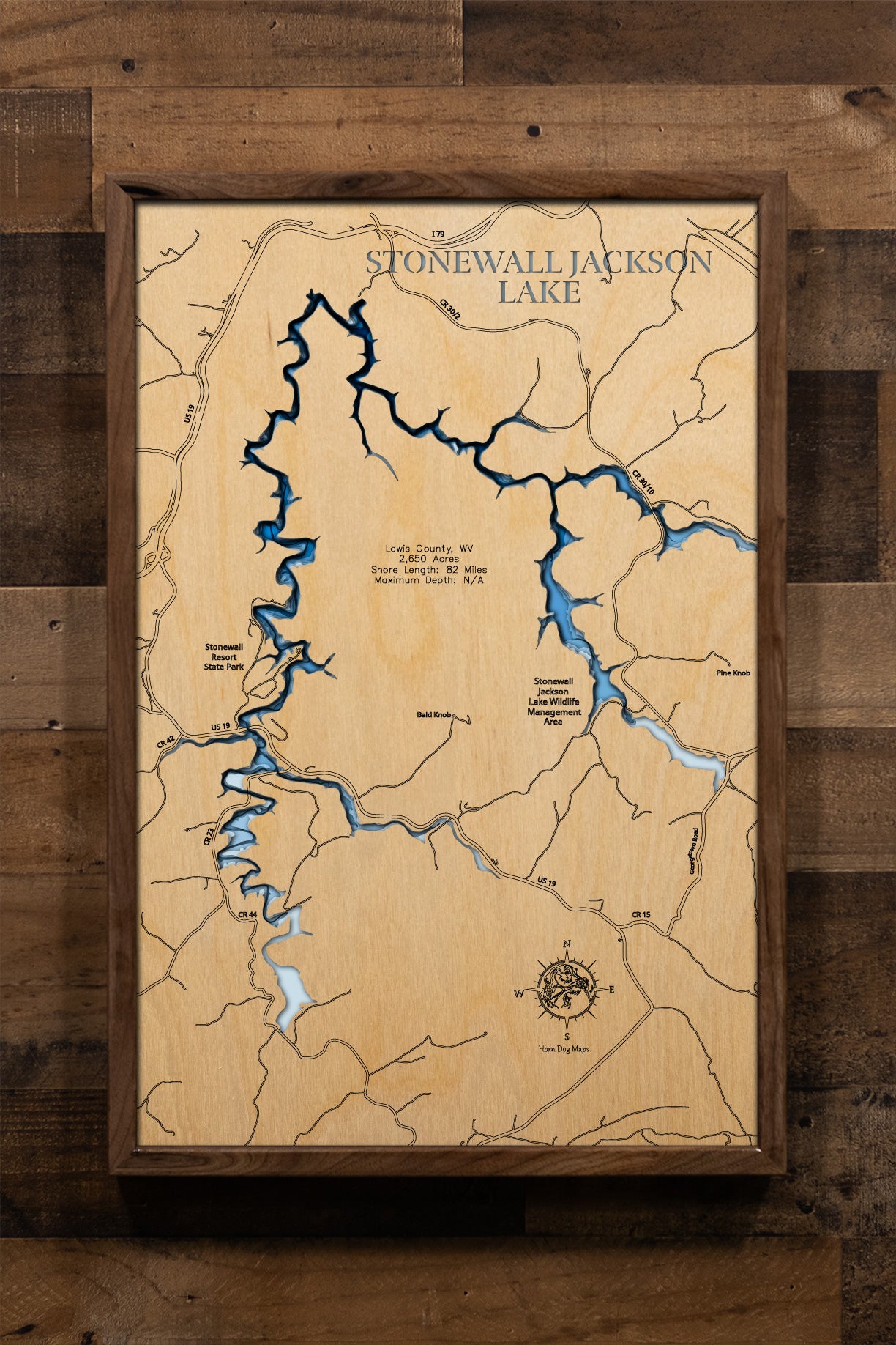 A precision laser-cut, multi-layered wooden map of Stonewall Jackson Lake in Lewis County, West Virginia. The natural wood top layer captures 82 miles of winding, wooded shoreline and the lake's dramatic V-shaped basin in fine detail, while a light-to-dark blue gradient highlights the water's depth and dimension. A distinctive, rustic statement piece for any Appalachian cabin, resort room, or West Virginia lake home.