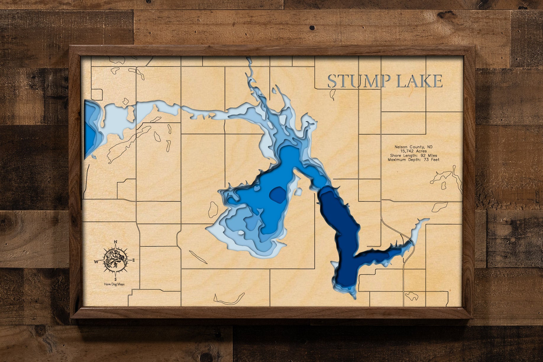 A highly detailed, laser-cut, and multi-layered wooden map of Stump Lake, a natural lake in Nelson County, North Dakota. The map shows the lake's distinct, sprawling shape and its 91.4-mile shoreline, along with depth contours reaching a maximum of 77.1 feet. The map highlights the unique, flooded bays and the general area near Stump Lake Park.