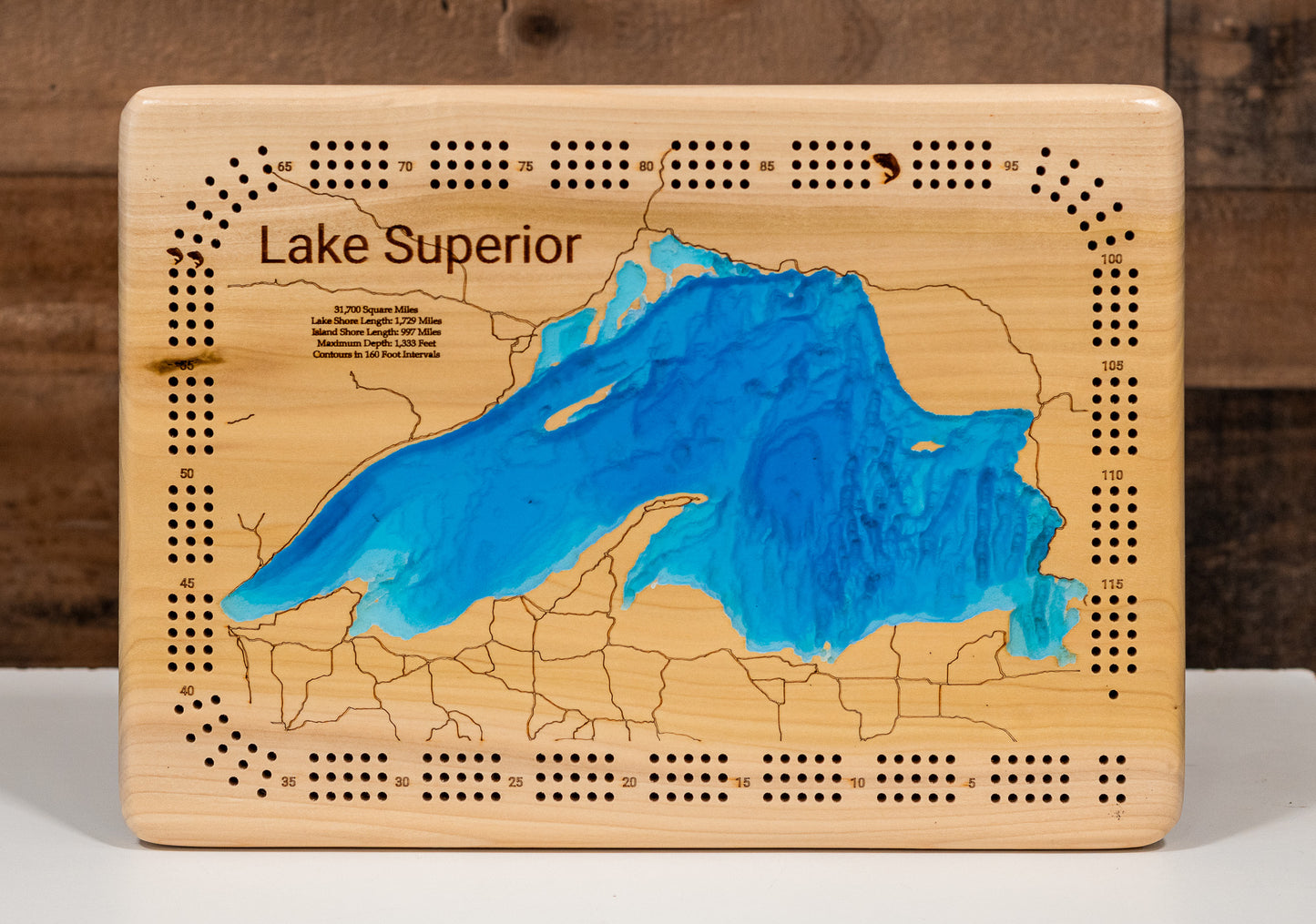 3D high definition Lake superior map in a maple frame on a cabin wall, showcasing detailed depth layers and shoreline features.