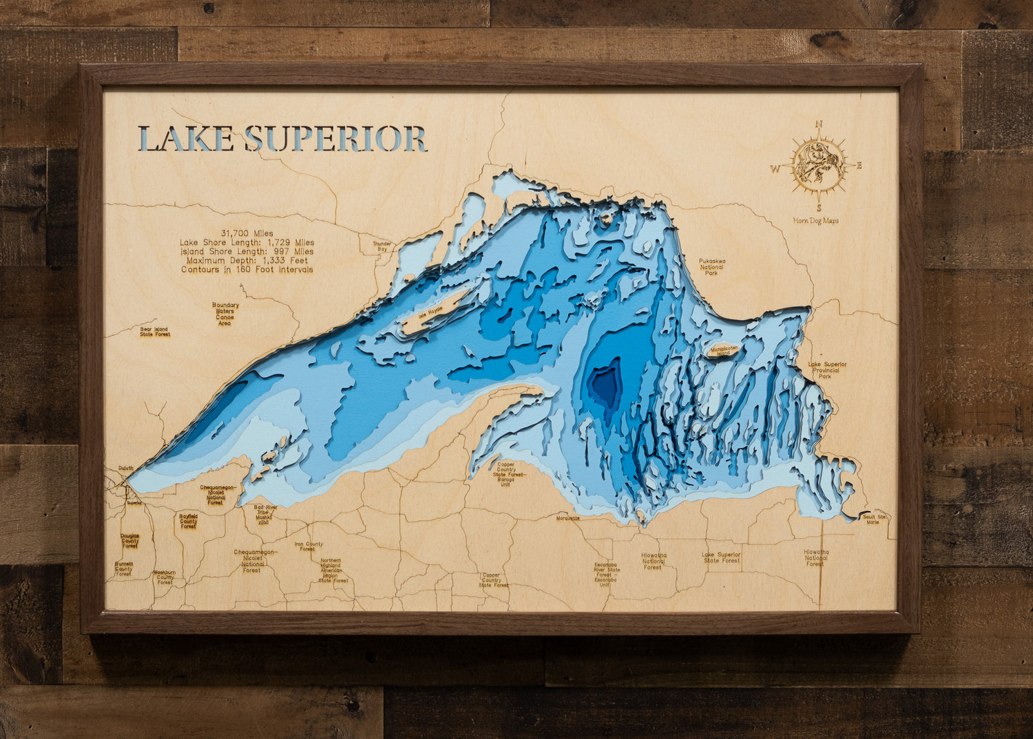 3D Lake Mille Lacs map in a walnut frame on a cabin wall, showcasing detailed depth layers and shoreline features.