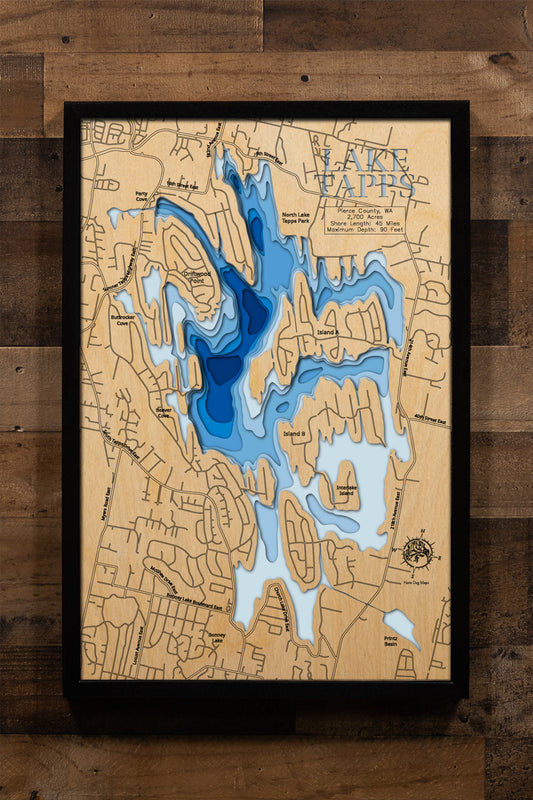 A meticulously crafted, multi-layered wooden topographic map of Lake Tapps in Pierce County, Washington, featuring laser-cut depth contours revealing the reservoir's 90-foot maximum depth, the intricate 45-mile shoreline with its distinctive islands and peninsulas, location markers for North Lake Tapps Park and Allan Yorke Park boat launches, and Mount Rainier's profile visible to the south.