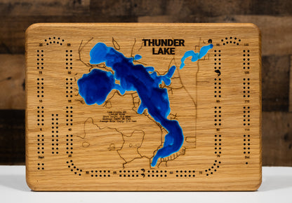 A laser-cut, layered wooden map of Thunder Lake in Cass County, Minnesota. The distinct shape of this natural lake, with its 15.9-mile shoreline, is clearly visible within the forested landscape of northern Minnesota. The varying depths of the lake, reaching a maximum of 95 feet, are represented by different layers of wood, illustrating its impressive underwater topography.
