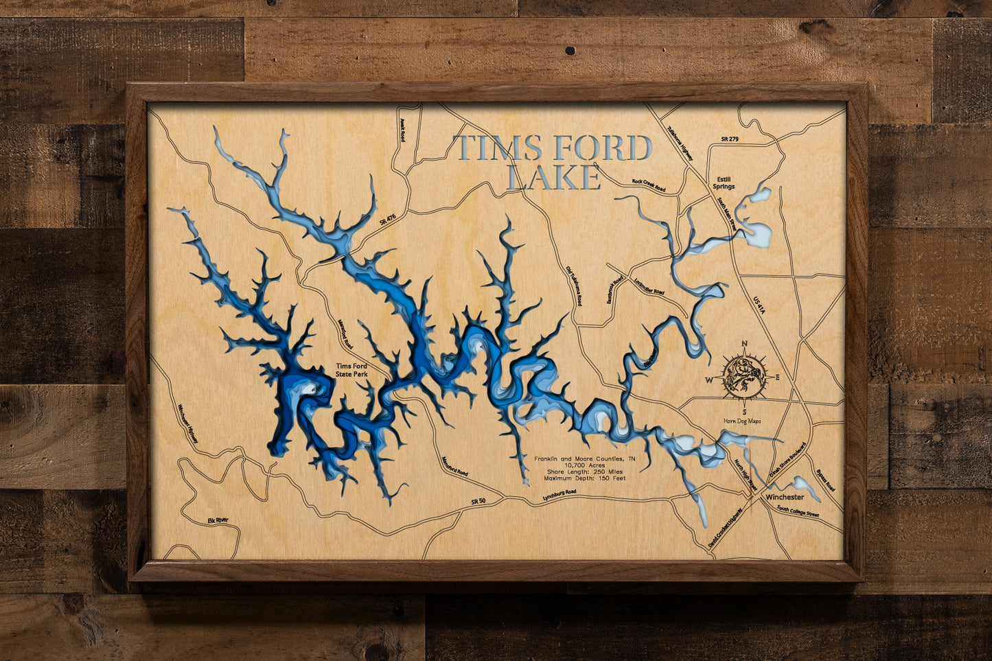 A meticulously crafted, multi-layered laser-cut wooden topographic map of Tims Ford Lake in Franklin and Moore Counties, Tennessee. The detailed design illustrates the reservoir's 34-mile length along the winding Elk River channel, 250 miles of intricate shoreline with numerous coves and embayments, depth contours revealing the 150-foot maximum depth near the dam, and the six distinctive islands scattered throughout the lake.