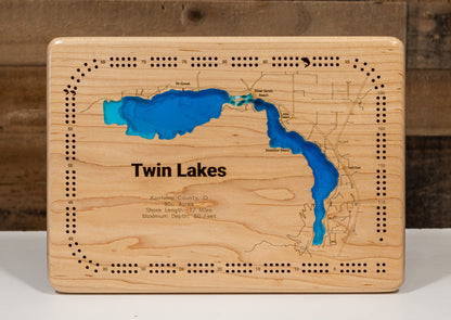 A precision laser-cut, multi-layered wooden map of Twin Lakes in 
Kootenai County, Idaho. The natural wood top layer meticulously 
captures the 17-mile shoreline, while the recessed water layers 
feature a vibrant light-to-dark blue gradient representing the 
60-foot depth. This elegant 3D topographic art piece is a 
sophisticated home decor item, perfect for cabin walls or modern 
interiors looking for a rustic, handcrafted touch.