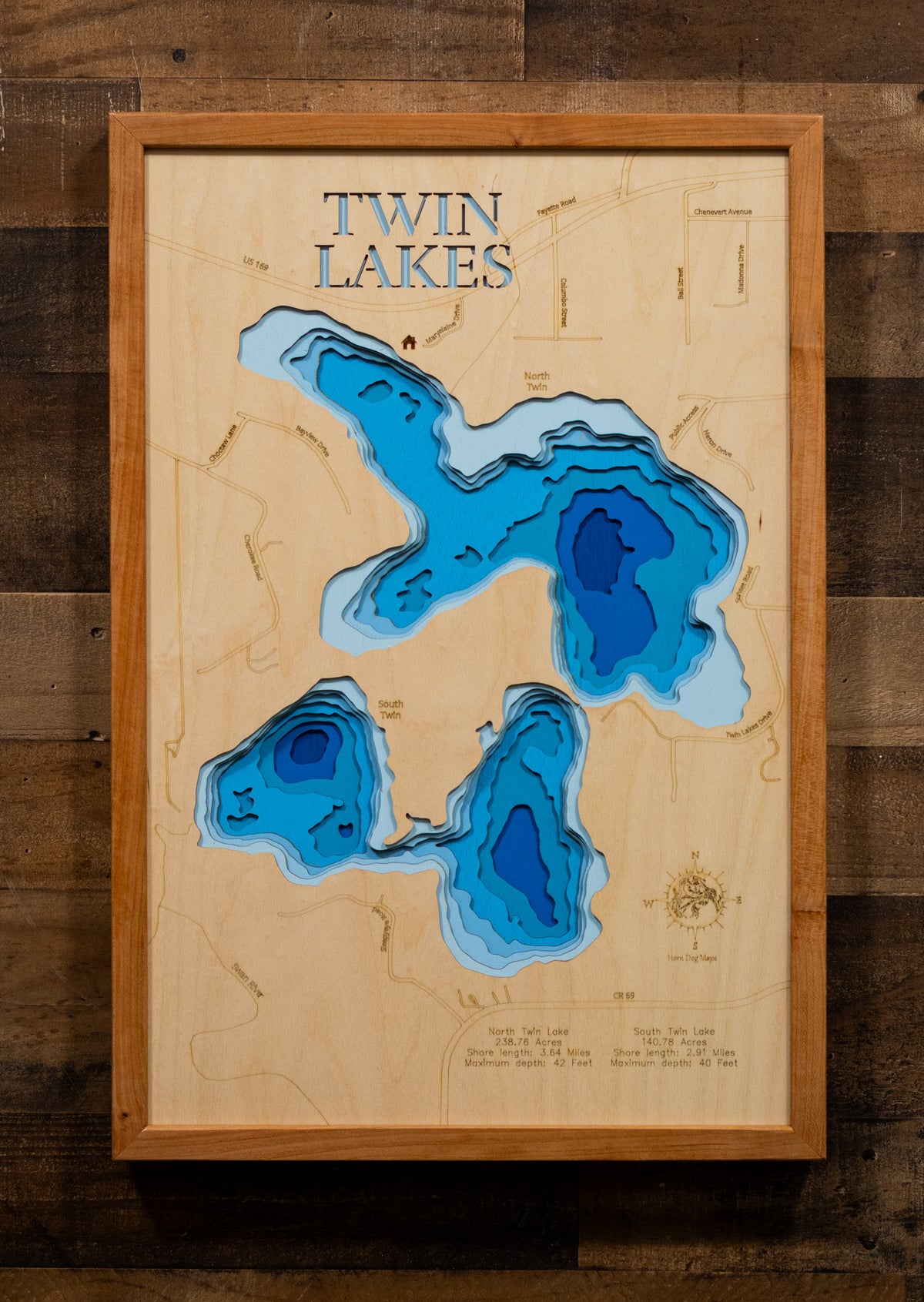 A precision laser-cut, multi-layered wooden map of North and South Twin Lakes in Itasca County, Minnesota, a connected pair of clear Northwoods lakes covering 418 combined acres alongside the city of Marble in the Iron Range. The natural wood top layer captures both shorelines and their connecting channel in fine detail, while a light-to-dark blue gradient conveys depths reaching 42 feet. A handcrafted statement piece for any Minnesota lake cabin, home, or outdoor enthusiast's wall.