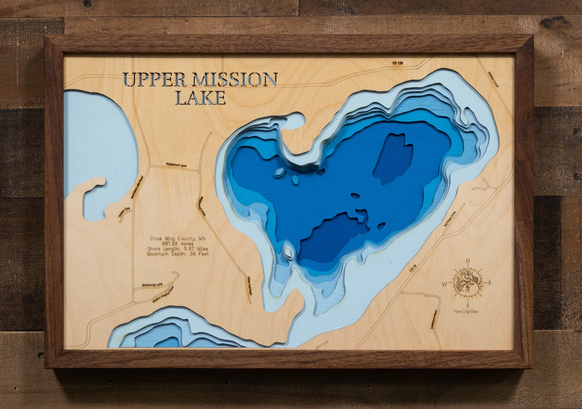 Detailed wooden relief map of Upper and Lower Mission Lakes in Crow Wing County, MN, showcasing its natural beauty.