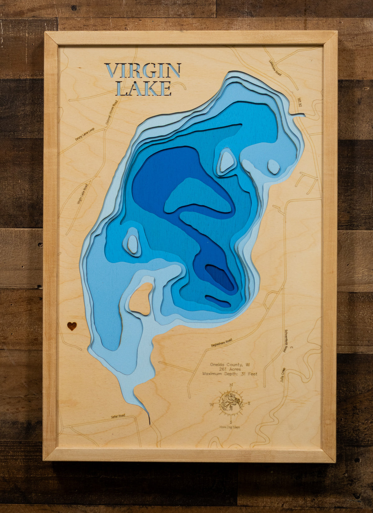 A precision laser-cut, multi-layered wooden map of Virgin Lake in Oneida County, Wisconsin, a 261-acre Northwoods lake near Three Lakes holding Muskie, Walleye, Pike, Bass, and Panfish. The natural wood top layer captures the lake's natural shoreline in fine detail, while a light-to-dark blue gradient conveys its 31-foot depth. A handcrafted statement piece for any Wisconsin lake cabin, home, or outdoor enthusiast's wall.