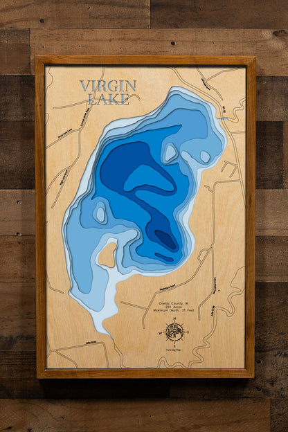 A precision laser-cut, multi-layered wooden map of Virgin Lake in Oneida County, Wisconsin, a 261-acre Northwoods lake near Three Lakes holding Muskie, Walleye, Pike, Bass, and Panfish. The natural wood top layer captures the lake's natural shoreline in fine detail, while a light-to-dark blue gradient conveys its 31-foot depth. A handcrafted statement piece for any Wisconsin lake cabin, home, or outdoor enthusiast's wall.