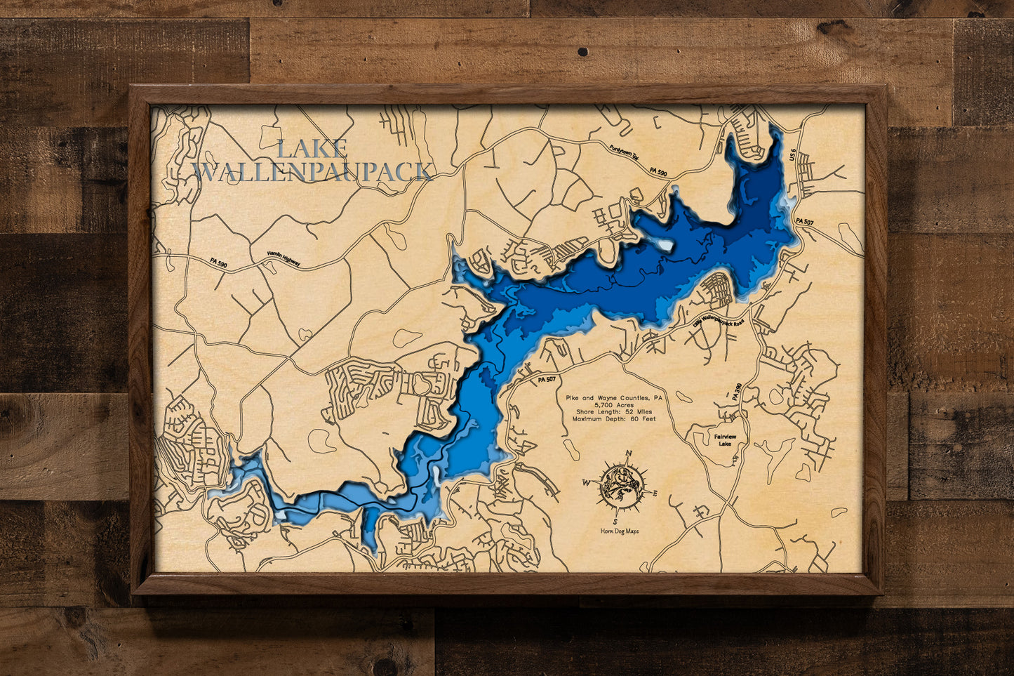 A highly detailed, laser-cut, and multi-layered wooden map of Lake Wallenpaupack, a large reservoir in Pike and Wayne Counties, Pennsylvania. The map shows the lake's distinct shape and its extensive 52-mile shoreline. The varying depths of the lake, reaching a maximum of 60 feet, are represented by different layers of wood.