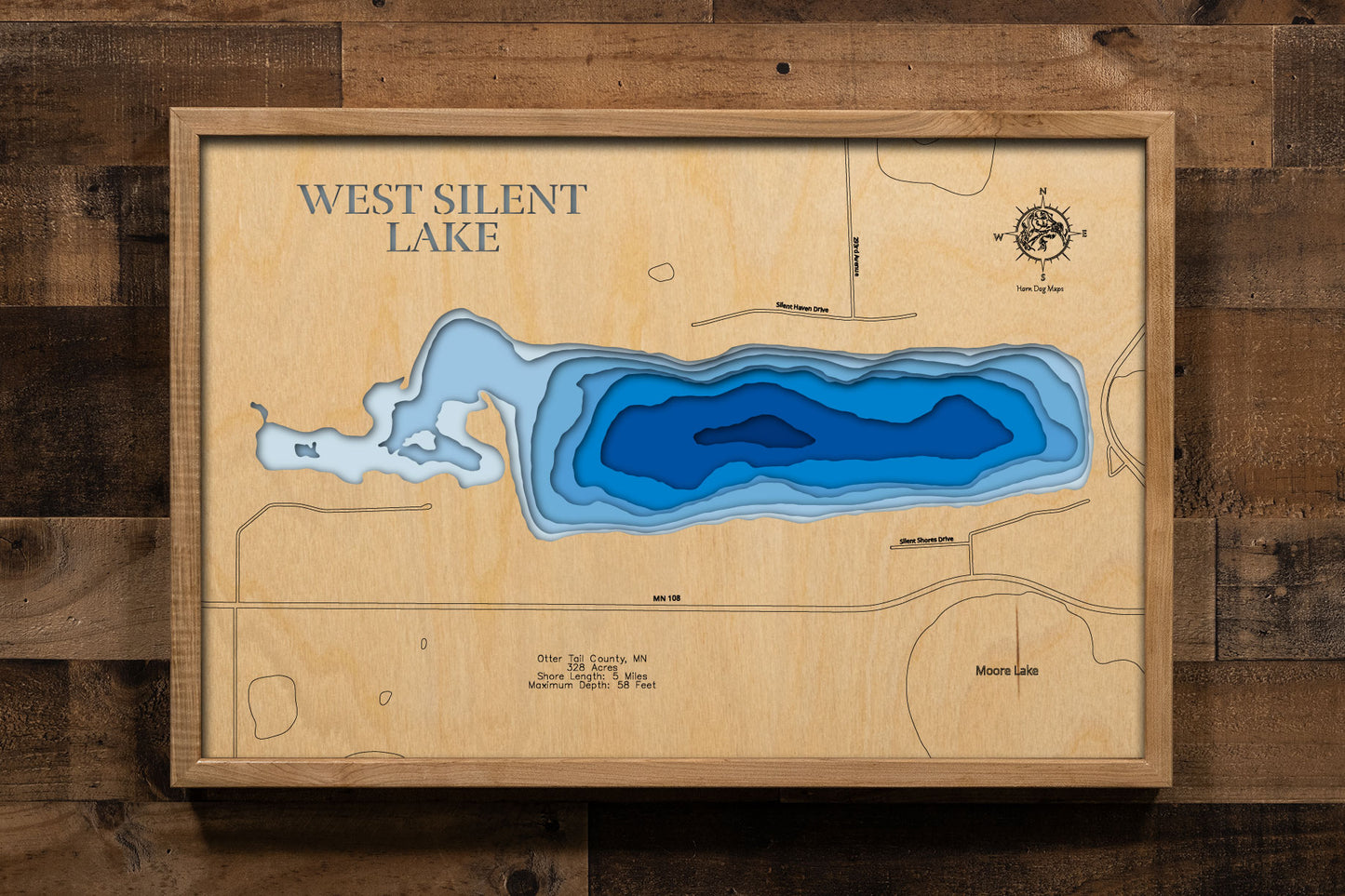A precision laser-cut, multi-layered wooden map of West Silent Lake in Otter Tail County, Minnesota, near Dent and Pelican Rapids in Minnesota's lake country. The natural wood top layer captures 5 miles of shoreline in fine detail, while a light-to-dark blue gradient conveys the lake's impressive 58-foot depth. A handcrafted statement piece for any Minnesota lake cabin, home, or outdoor enthusiast's wall.
