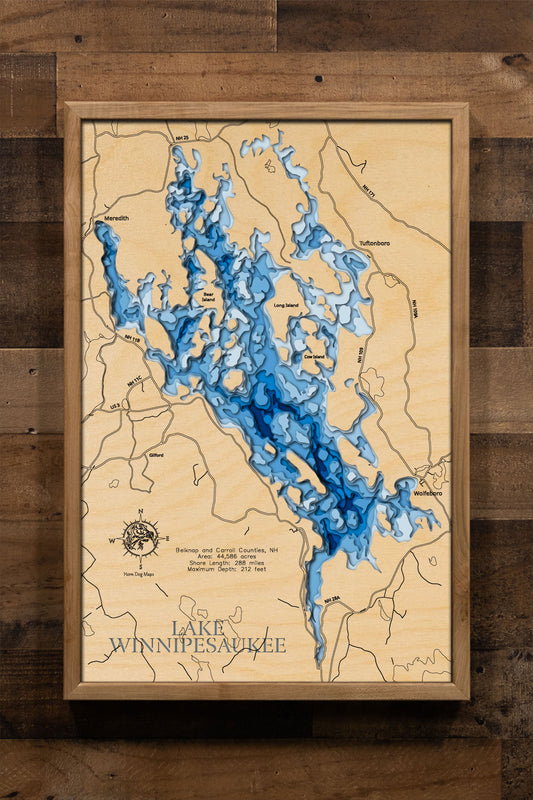 A laser-cut, layered wood map of Lake Winnipesaukee, New Hampshire, highlighting its expansive shoreline, numerous islands, and surrounding towns in Belknap and Carroll Counties.