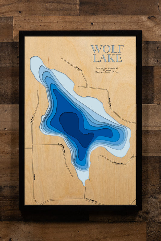 A precision laser-cut, multi-layered wooden map of Wolf Lake in Fond du Lac County, Wisconsin. The natural wood top layer captures the shoreline of this peaceful Kettle Moraine-area lake in fine detail, while a light-to-dark blue gradient highlights its 47-foot depth. A handcrafted statement piece for any Wisconsin lake home, cabin, or outdoor enthusiast's wall.