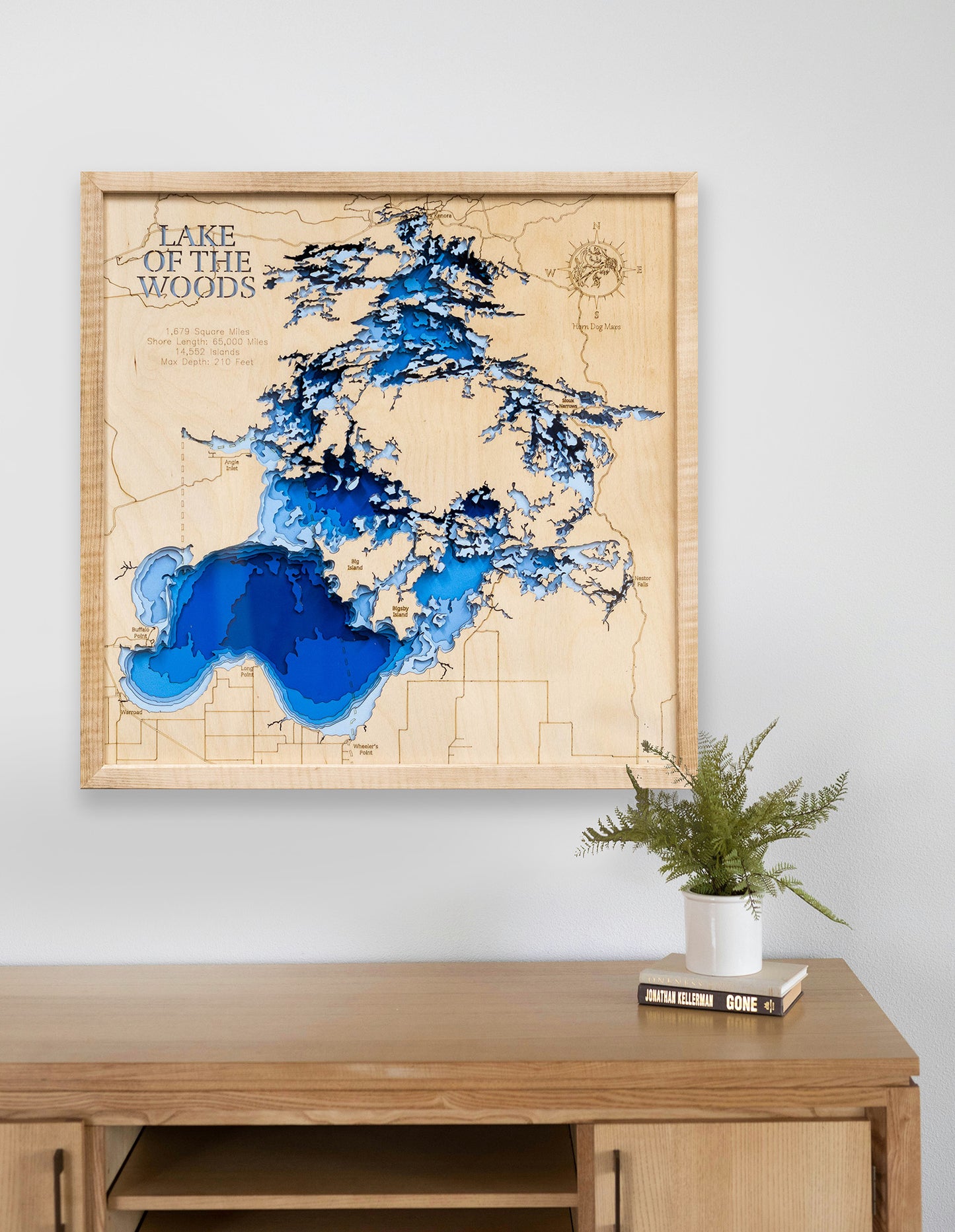 3D Lake of the Woods map in a maple frame displayed above a modern desk, highlighting detailed depths and shorelines.