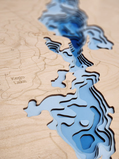 Closeup of a 3D lake map showcasing individual layers with a light blue to dark blue gradient for water depths and a light natural birch land layer.